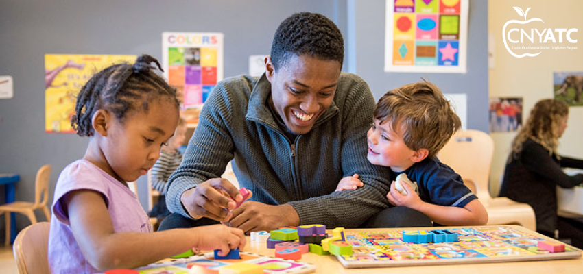 CNY ATC Homepage Banner- A male teacher working at a table with two students
